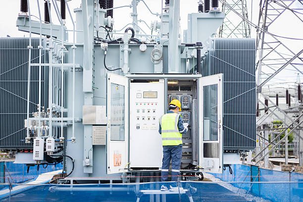 Engineer testing a transformer control panel at a substation